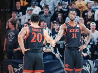 Matt Bradley y Nathan Mensah dándose la mano durante el triunfo de San Diego State en Utah State.