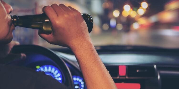 Conductor al volante consumiendo alcohol