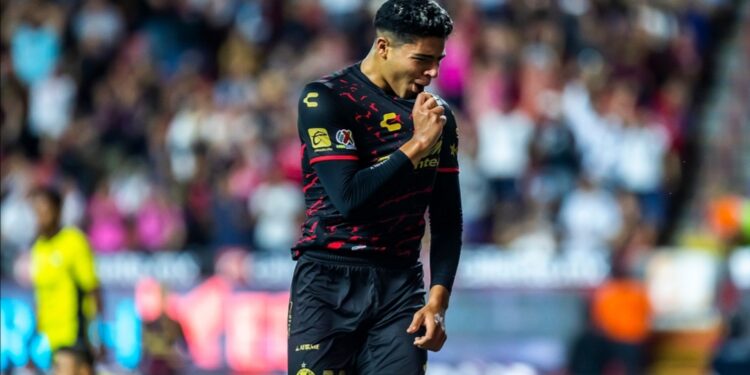 Víctor Guzmán besando la camiseta tras su gol ante Mazatlán.