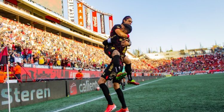 Joaquin Montecinos celebrando con Lisando López el primer gol de Xolos ante América.
