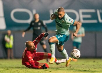 Kyle Vassell buscando evitar al portero rival de Roots.