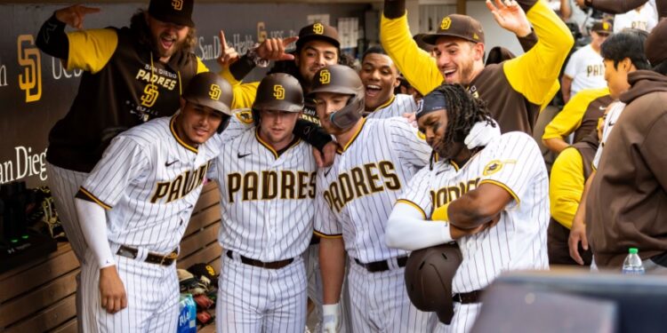 Brandon Drury felicitado por sus compañeros en el dugout por su grand slam en su debut.