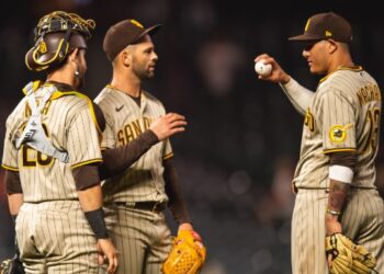 Nick Martínez con Austin Nola y Manny Machado tras el salvamento del lanzador.