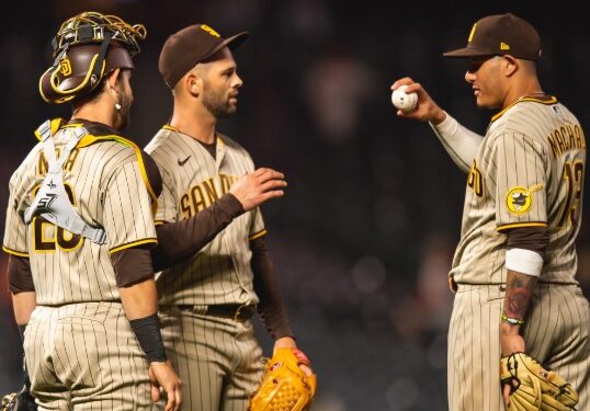 Nick Martínez con Austin Nola y Manny Machado tras el salvamento del lanzador.