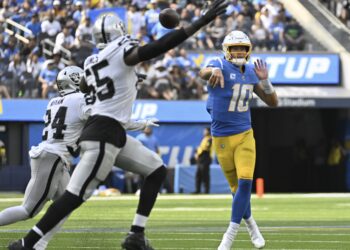 Justin Herbert lanzando un pase de anotación ante Raiders.