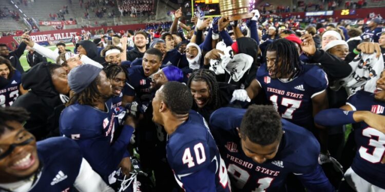 Los Bulldogs celebrando el mantener el viejo contenedor de aceite tras vencer a los Aztecs.