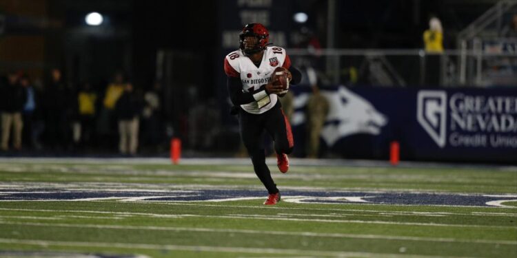 Jalen Mayden corriendo con la pelota para obtener yardas para los Aztecs ante el Wolfpack.
