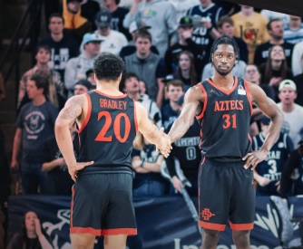 Matt Bradley y Nathan Mensah dándose la mano durante el triunfo de San Diego State en Utah State.