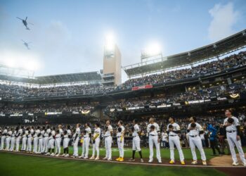 Los jugadores de los Padres durante el himno nacional de los Estados Unidos previo al inicio del juego inaugural.