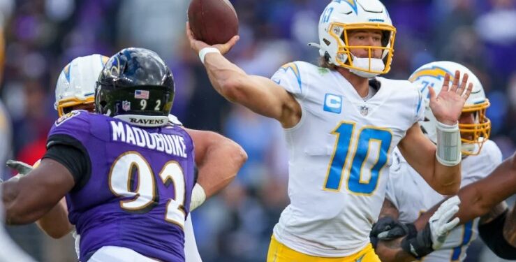 Justin Herbert lanzando un pase ante la defensa de Ravens.