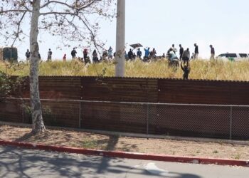 Migrantes en muro fronterizo lado estadounidense