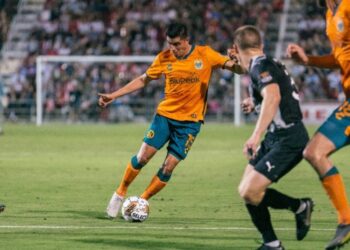Joe Corona buscando quitarse a rivales de San Antonio durante el agónico empate sabatino.