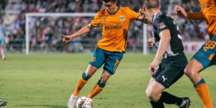 Joe Corona buscando quitarse a rivales de San Antonio durante el agónico empate sabatino.