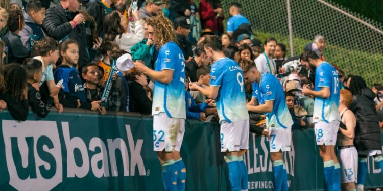 Los jugadores del Loyal firmando autógrafos tras el empate en casa.