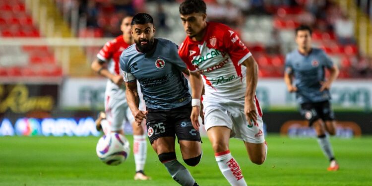 Pedro Alexis Canelo buscando la pelota ante la defensa de Necaxa.