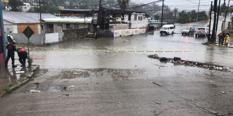 Rescatan a taxista varado en corriente de agua en la colonia Obrera